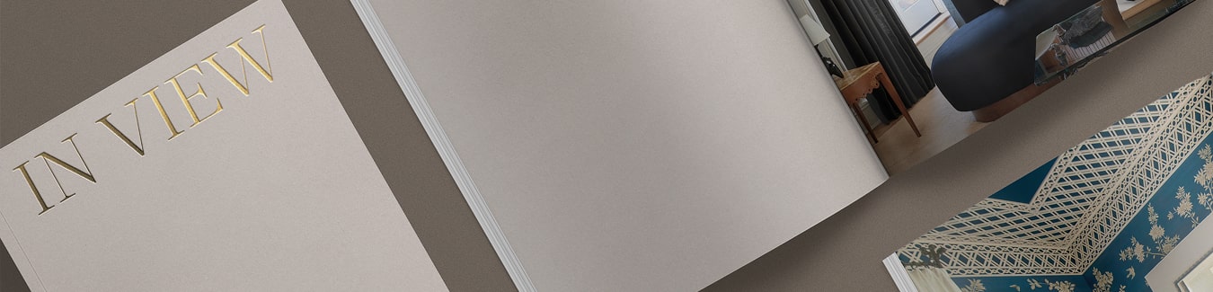 Several copies of The Shade Store 2025 Lookbook are laid out artistically on a neutral colored table