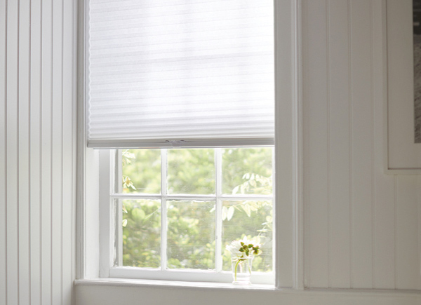 A window featuring a pleated cellular shade in 3/4 inch Single Cell LF and color Lace in an all white Bathroom