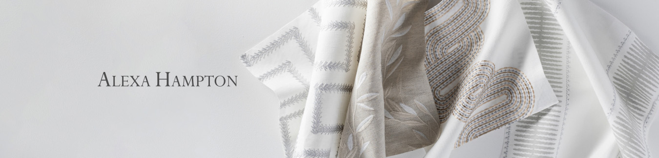 White table top featuring Alexa Hampton logo with fabric swatches in various patterns in shades of grey and tan.