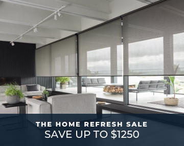 Floor to ceiling windows featuring light filtering roller shades in a grey living room with two couches with promo text