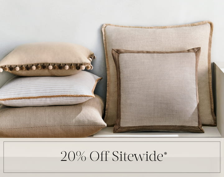 20% Off Sitewide in black text over an image of Square Pillows in neutral fabrics with trim.
