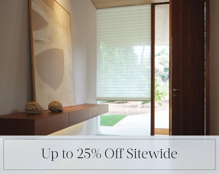 Up to 25% Off Sitewide in black text over an image of a window with a light filtering Pleated Shade.