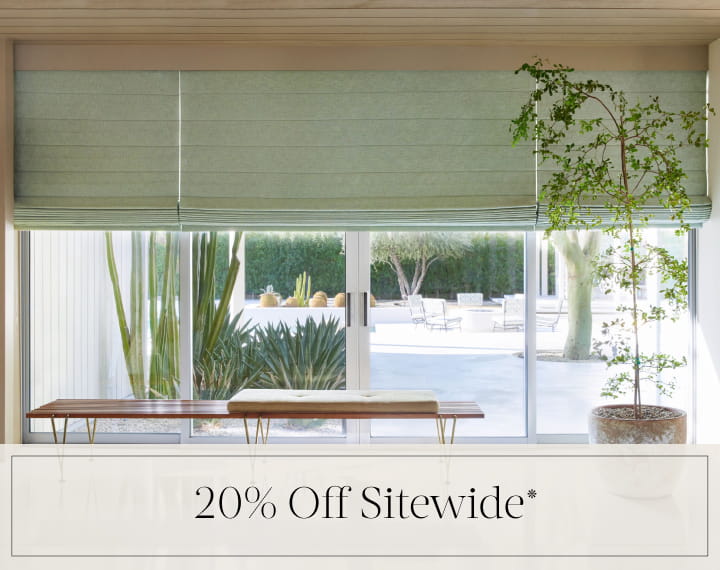 20% Off Sitewide in black text over an image of living room windows with sage green Roman Shades.