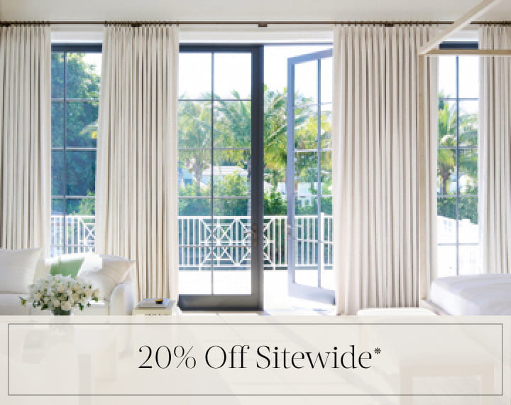 20% Off Sitewide in black text over an image of Tailored Pleat Drapery on bedroom patio doors.
